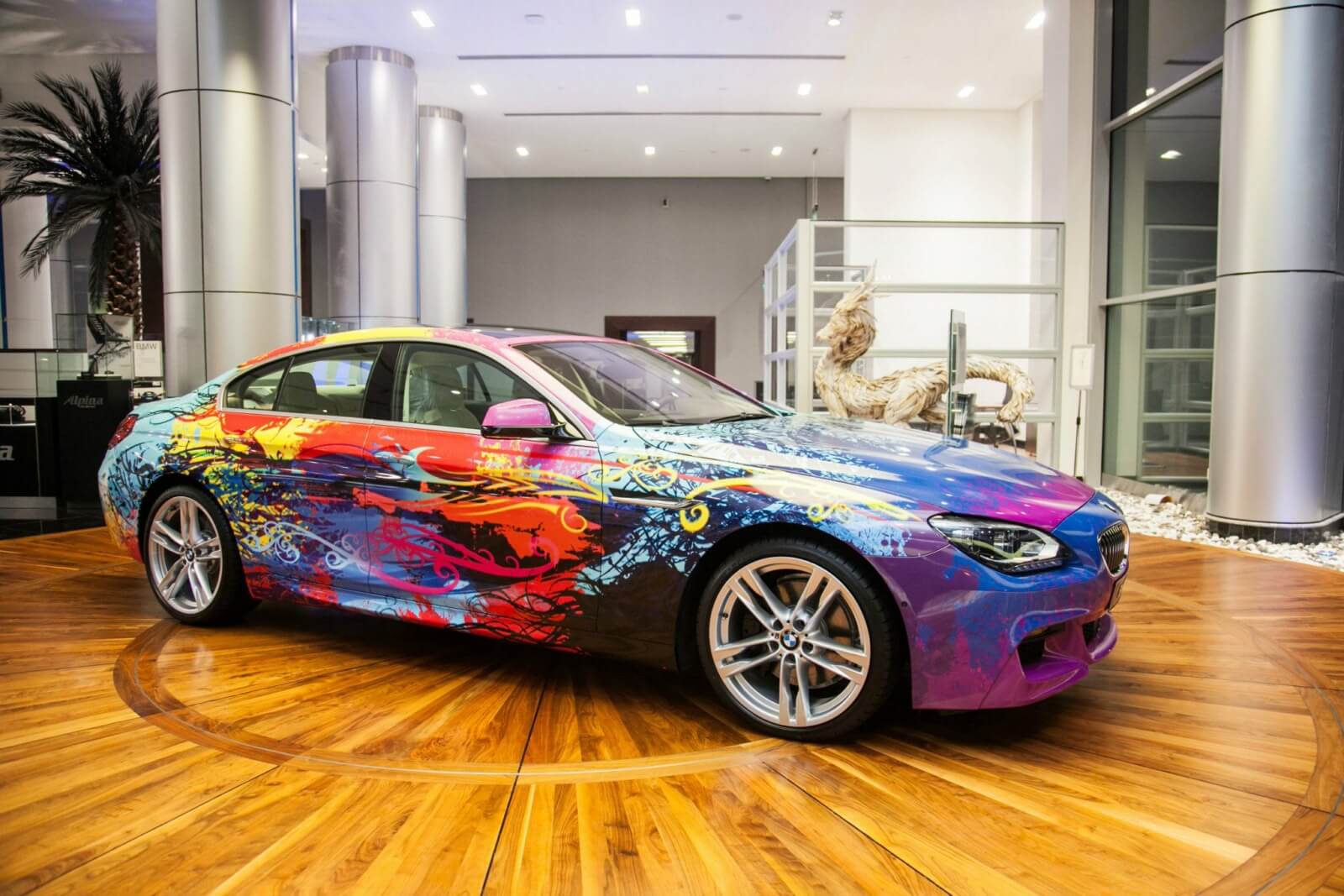 A colorful bmw car is parked in a showroom
