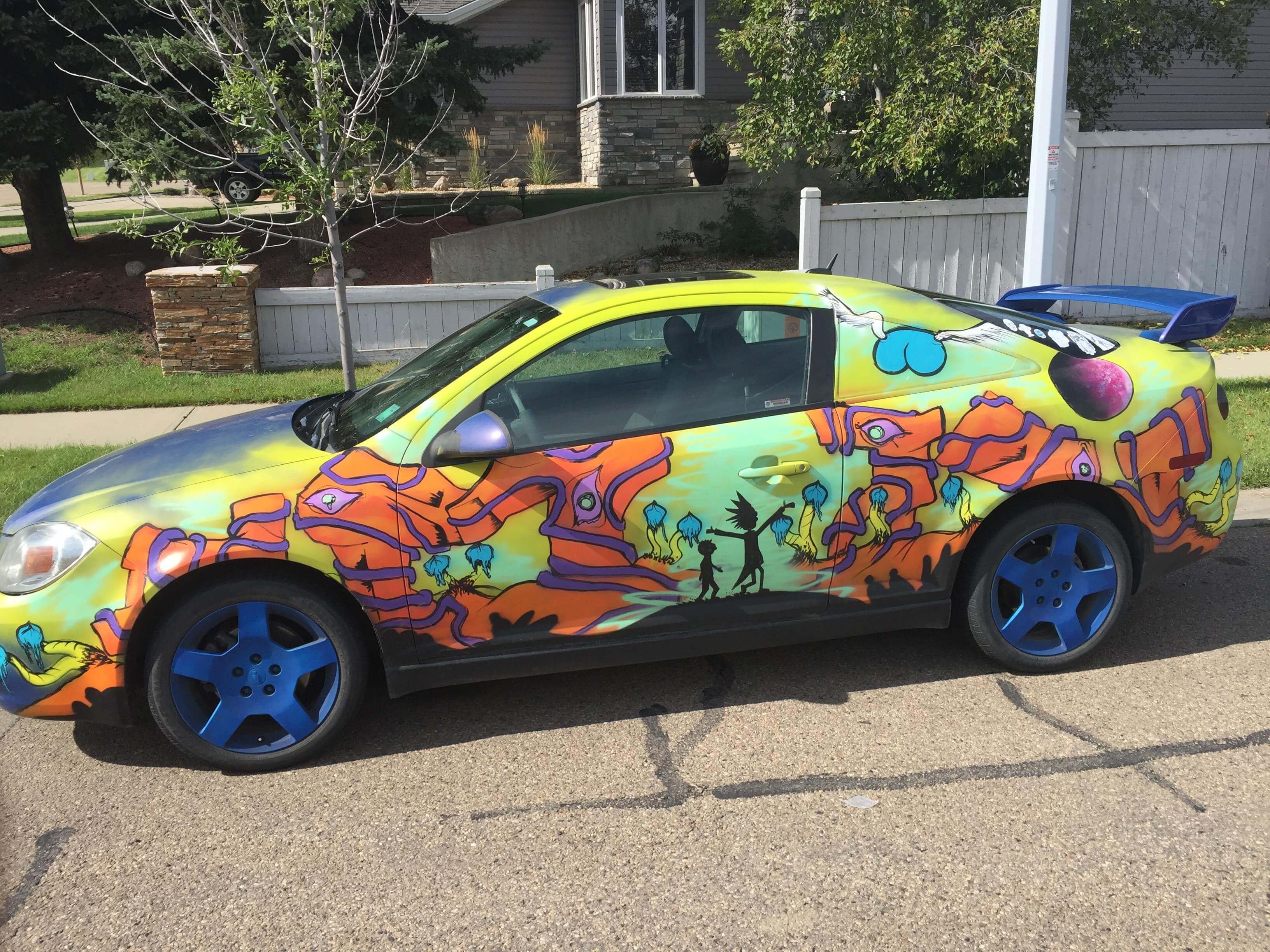 A colorful car parked on the side of the road
