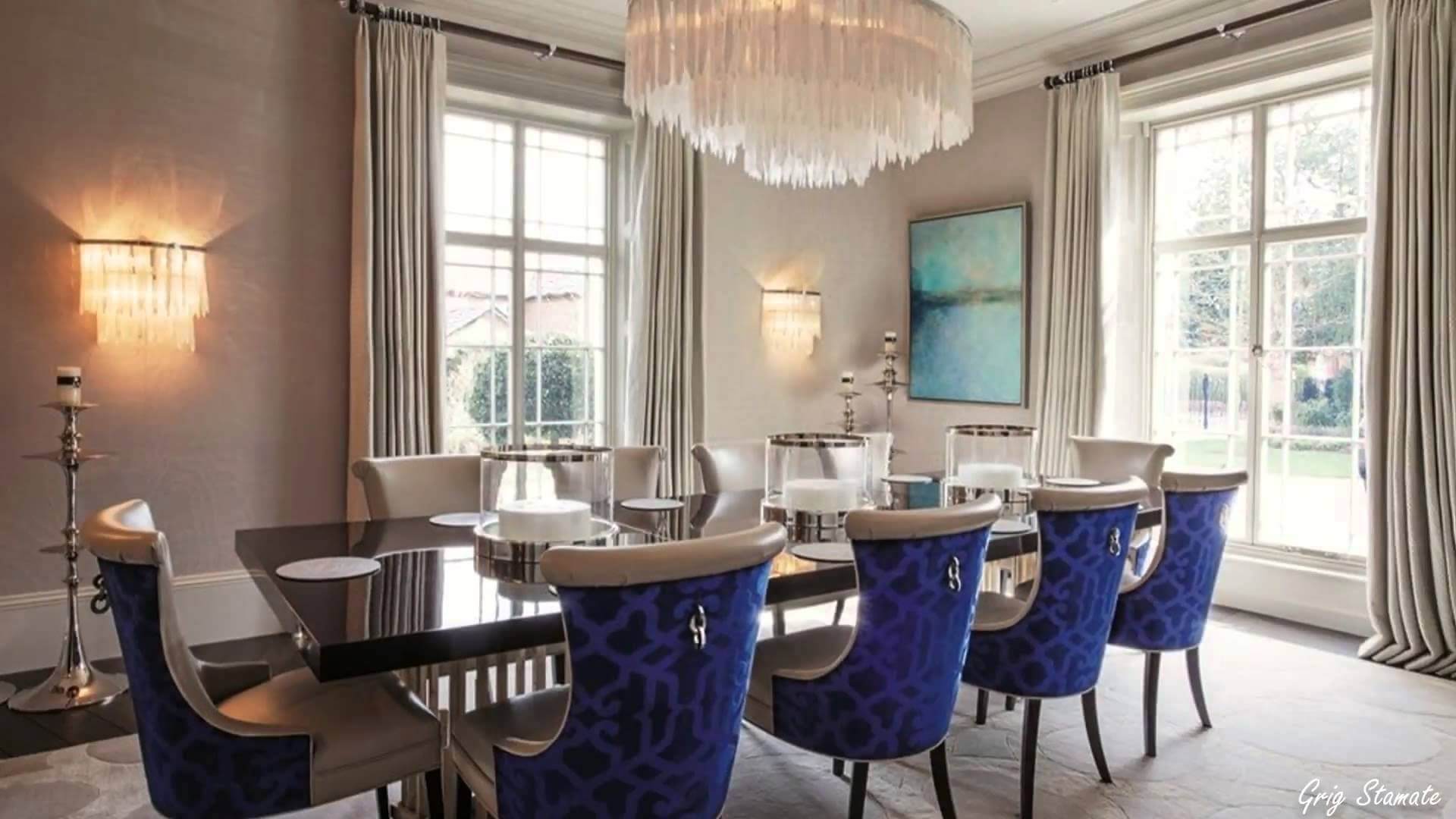 A dining room with blue chairs and a chandelier
