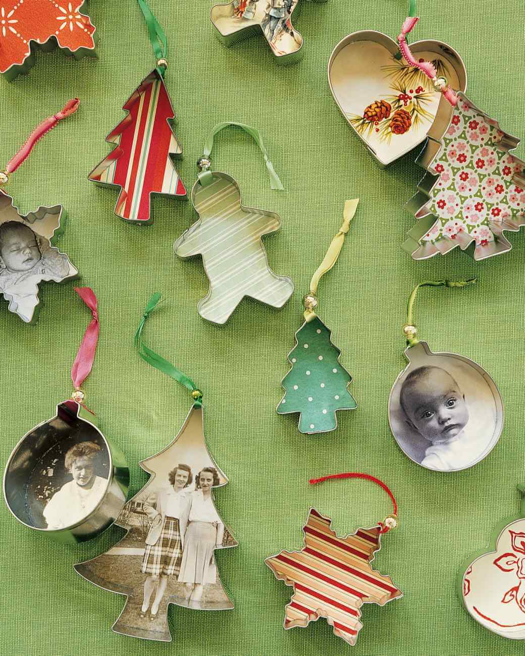 A group of christmas ornaments hanging from a green wall
