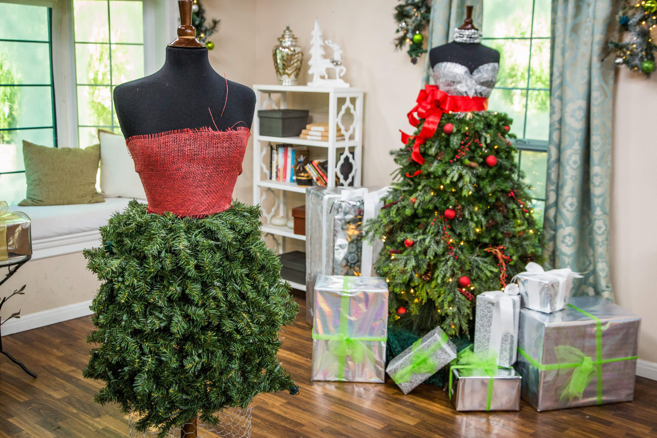 A mannequin dressed in a red dress next to a christmas tree
