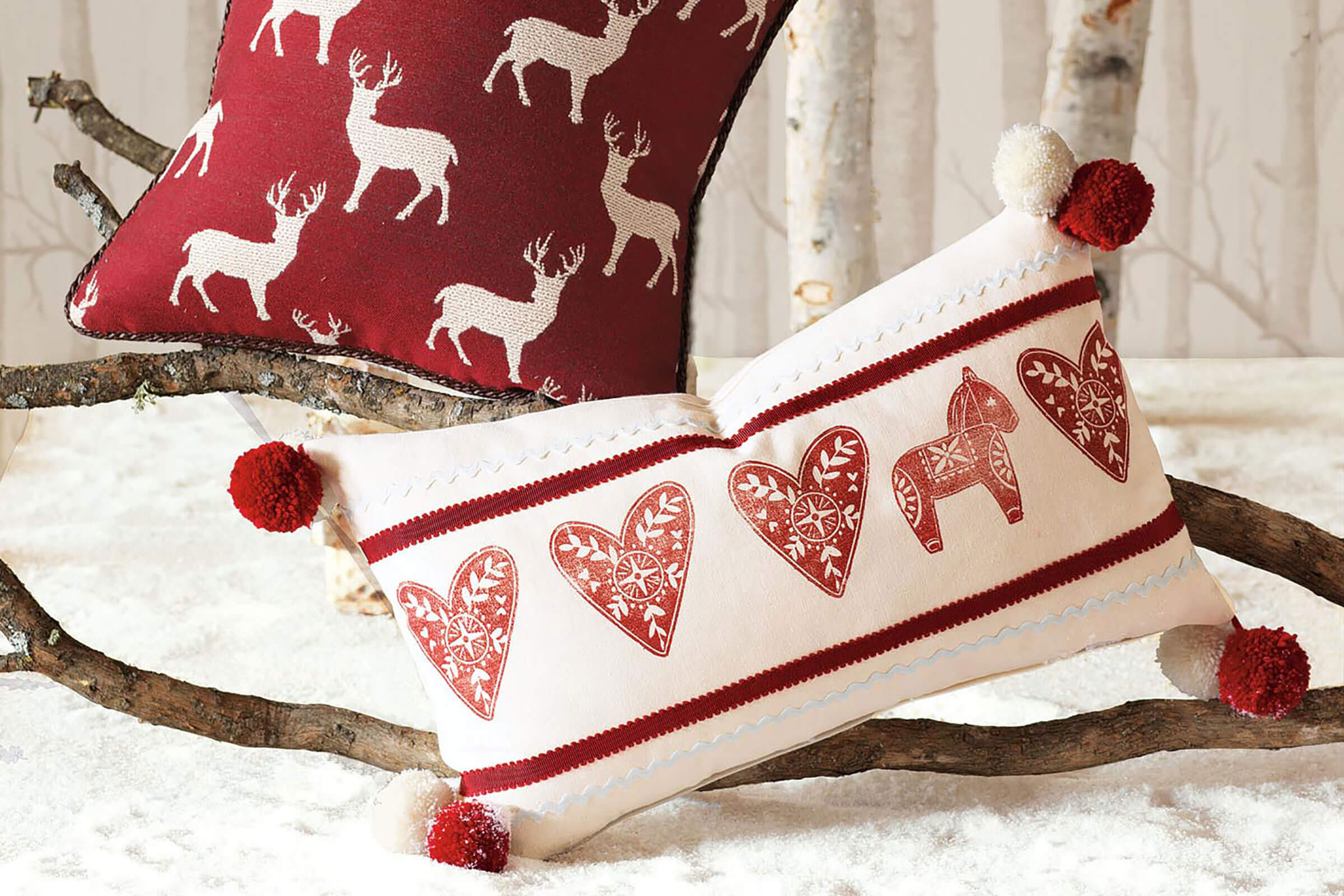 Two red and white decorative pillows on a bed
