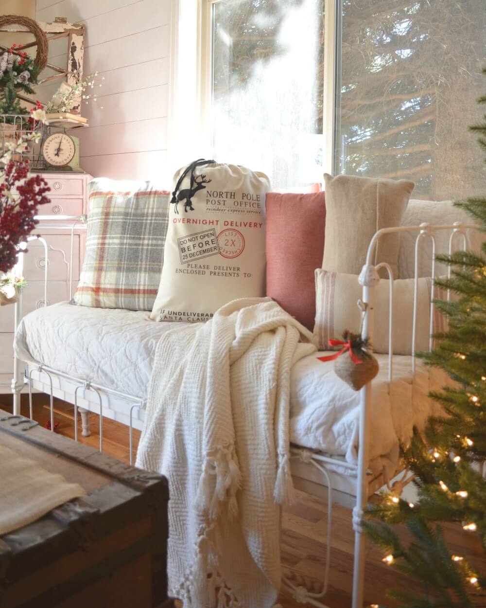 A white day bed sitting next to a christmas tree
