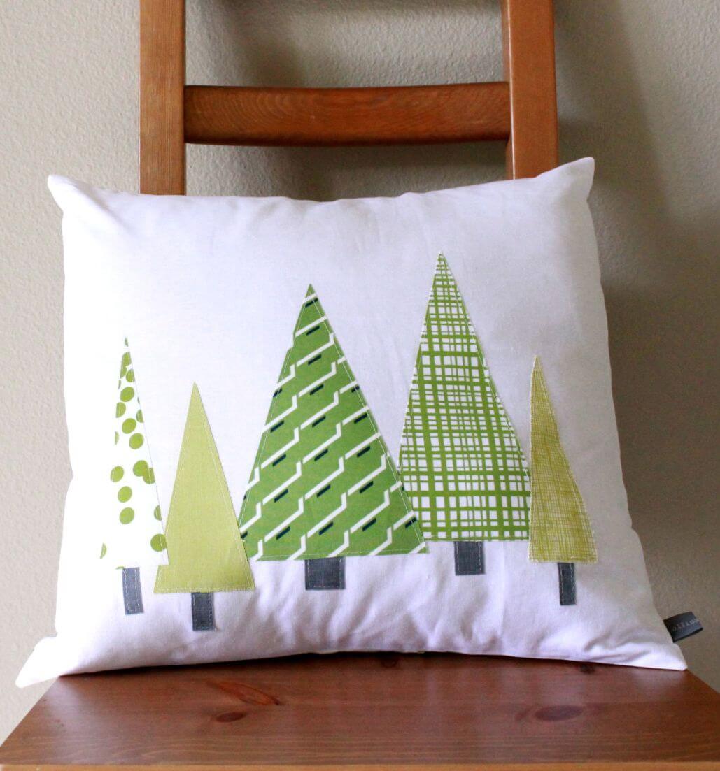 A white pillow with green trees on it
