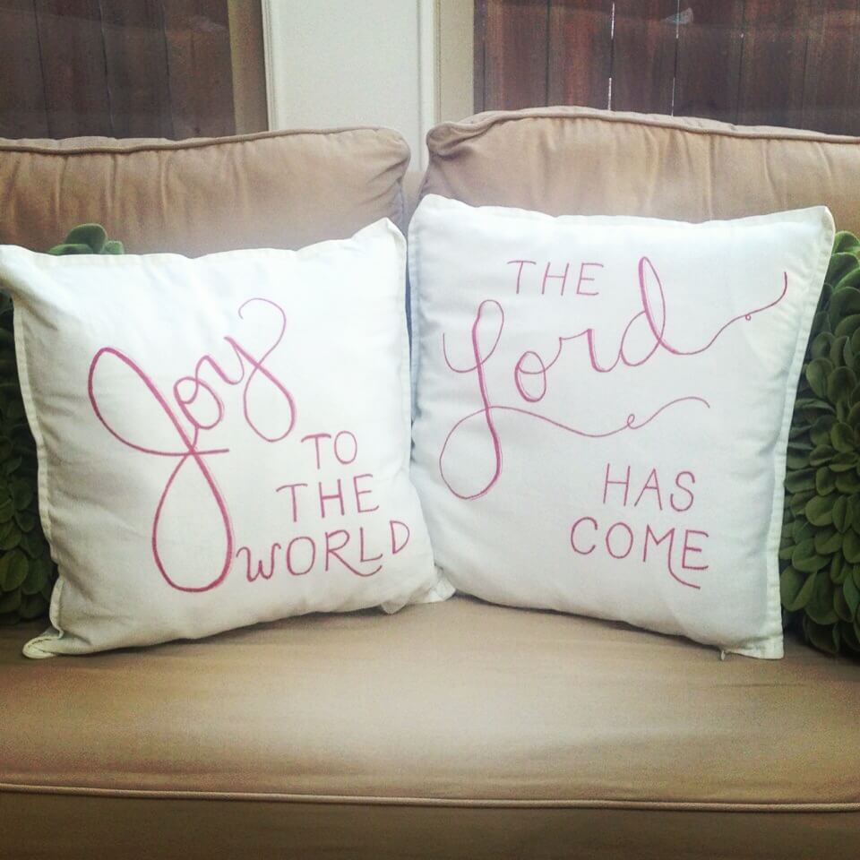Two pillows that say god to the world and god to the world
