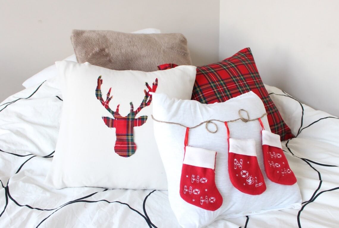 A bed topped with pillows and christmas stockings
