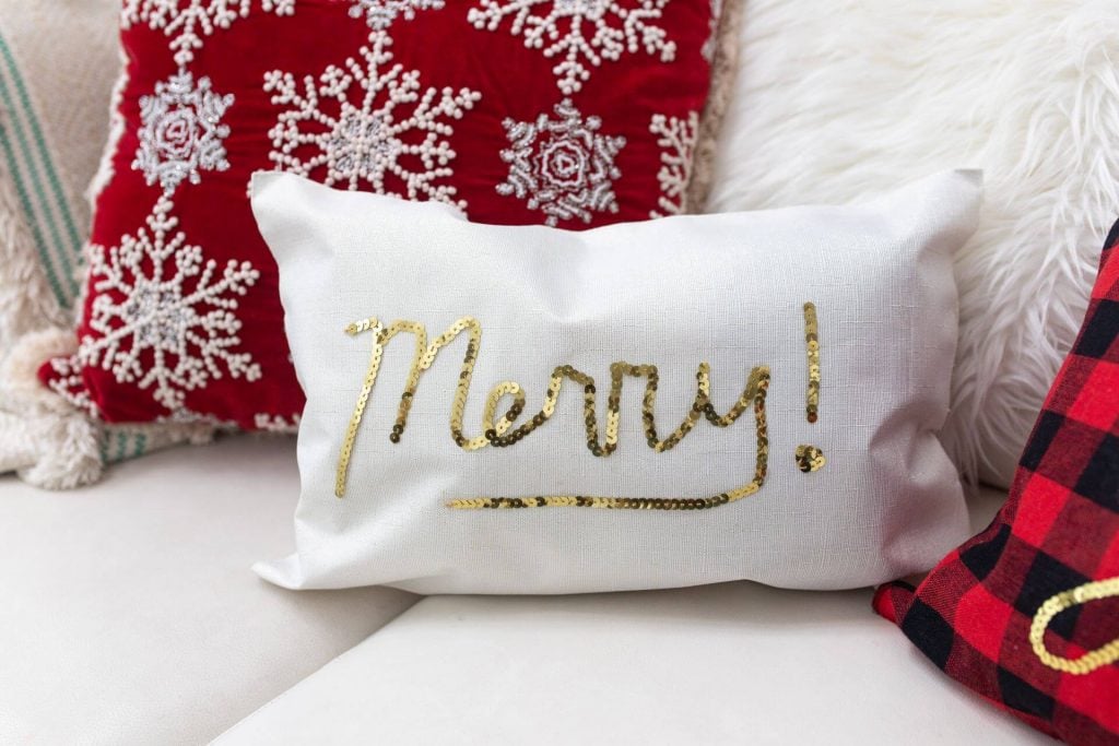 A close up of a merry christmas pillow on a couch
