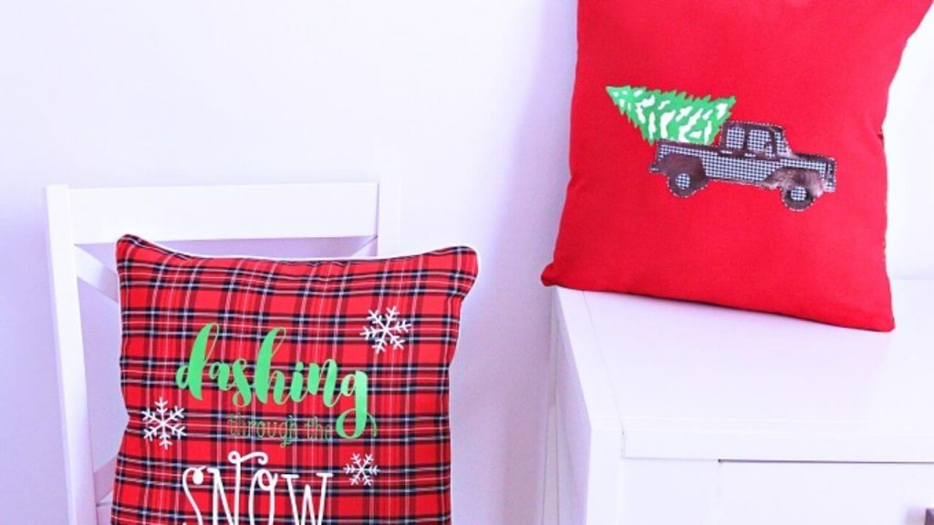 A red pillow sitting on top of a white chair
