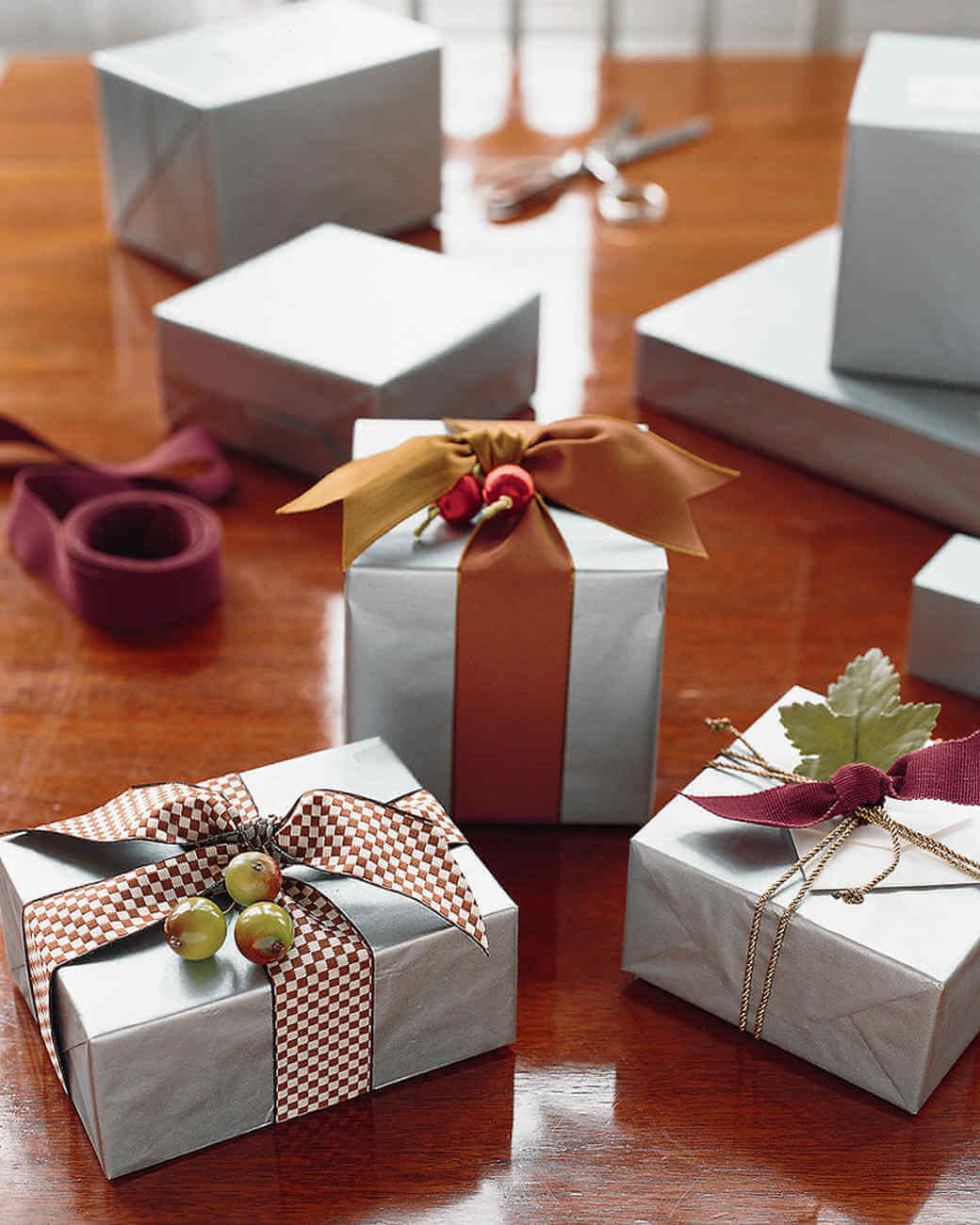 Four wrapped presents sitting on top of a wooden table
