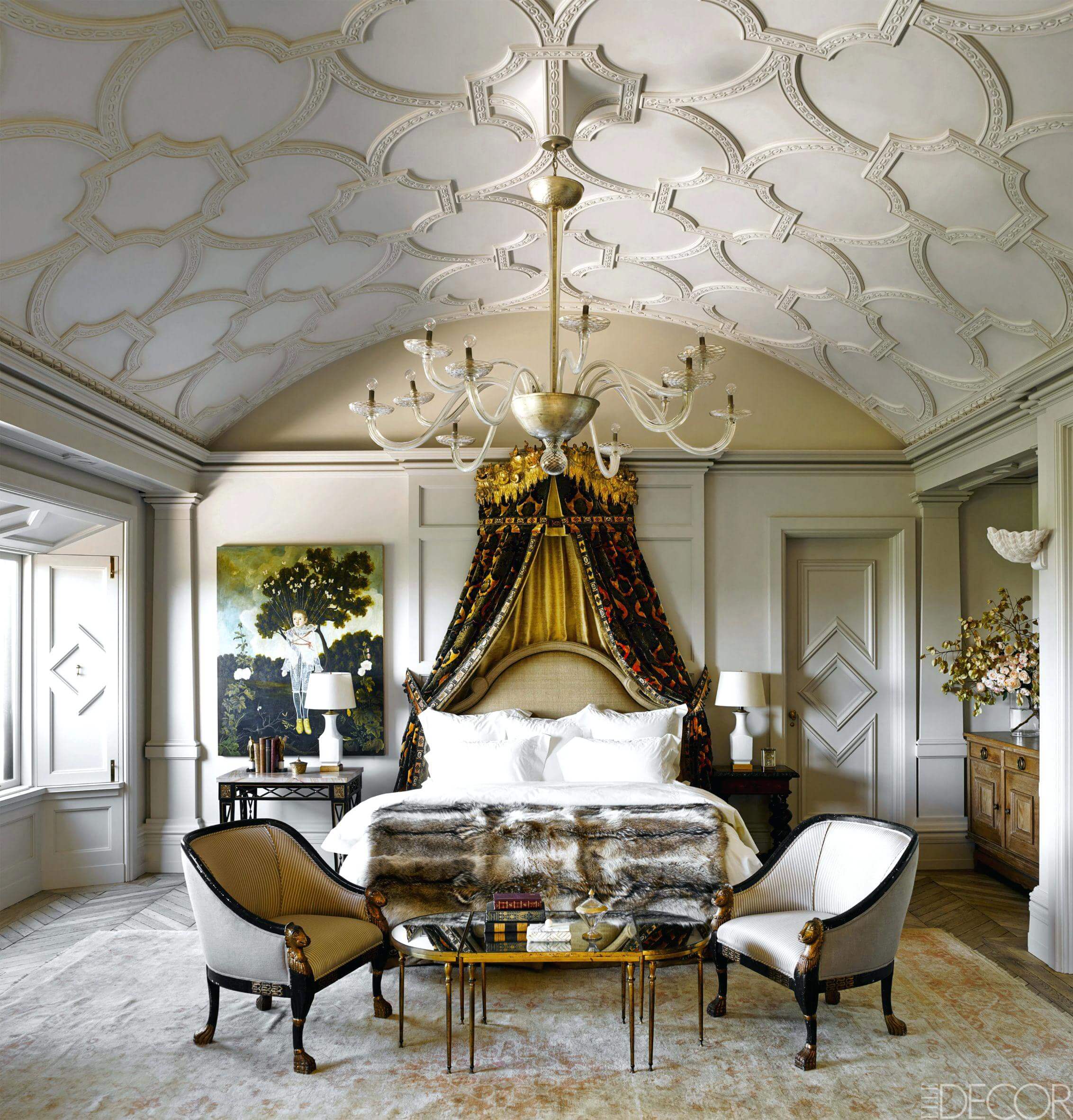 A fancy bedroom with a canopy bed and chandelier
