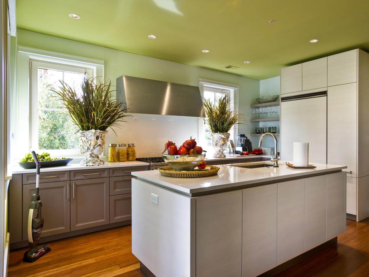 A kitchen with a center island with a bowl of fruit on it
