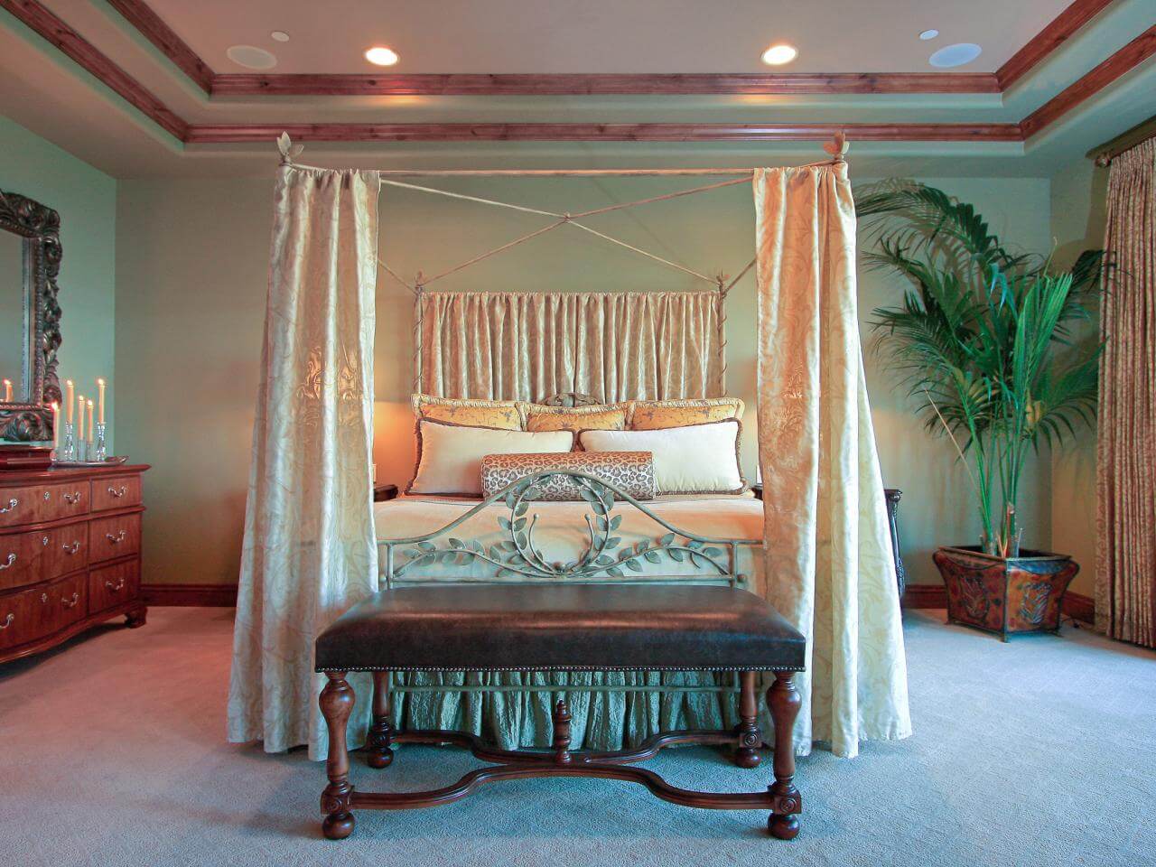 A bedroom with a canopy bed and a bench
