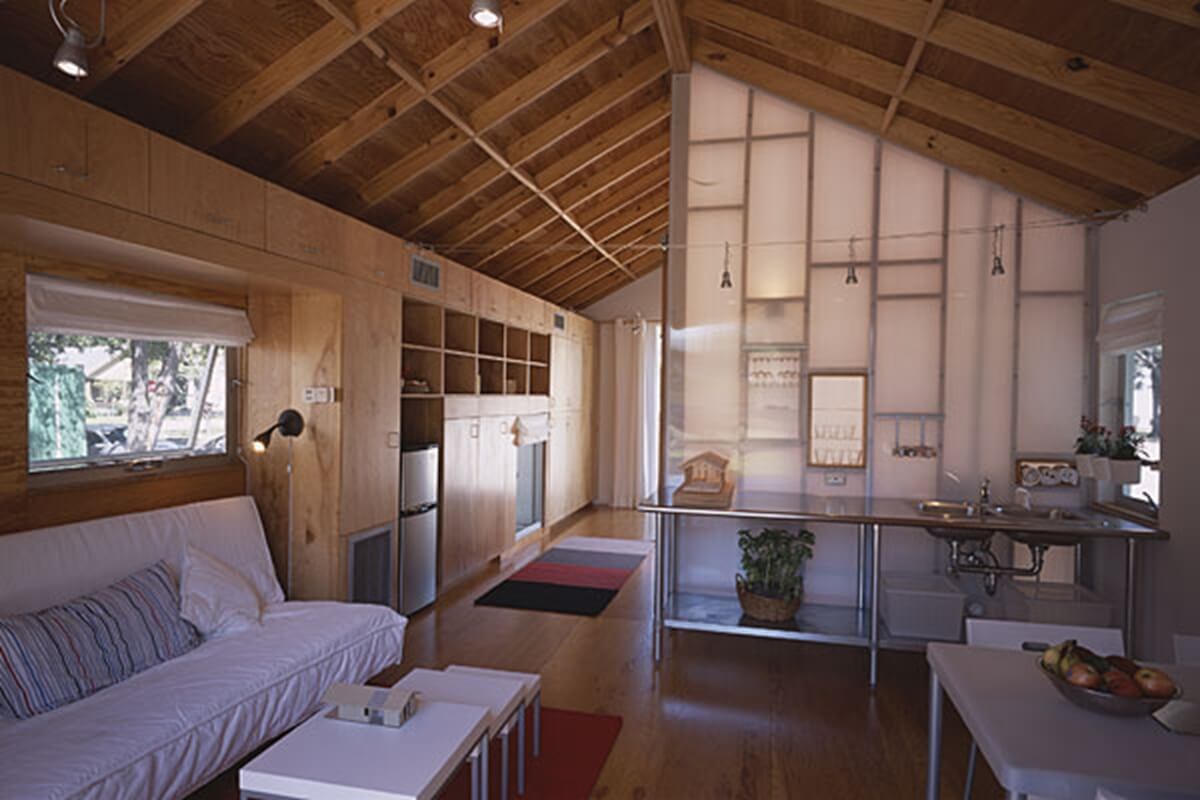 A living room with a couch a table and a refrigerator
