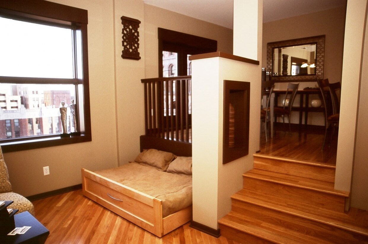 A bed sitting on top of a wooden floor next to a window
