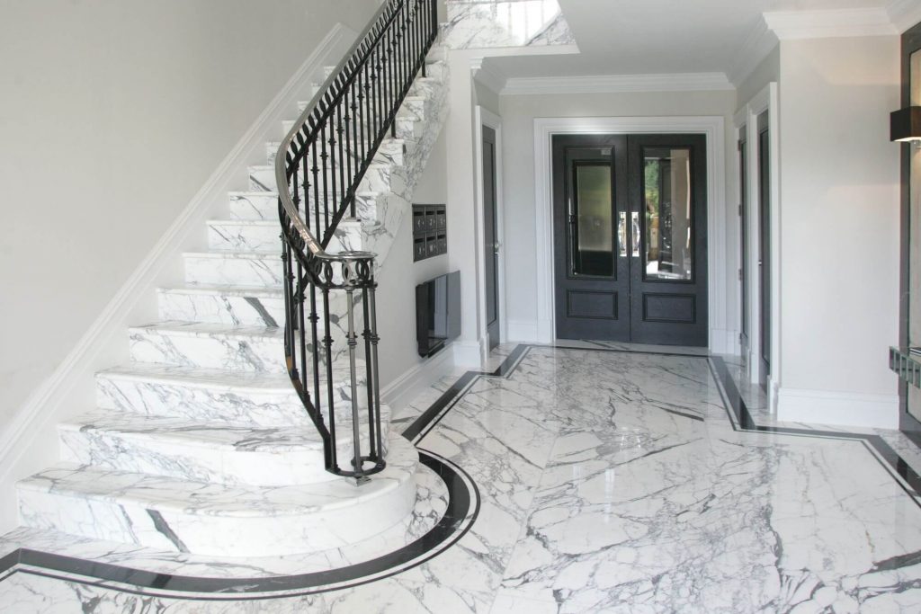 A white staircase with a black railing and a black door
