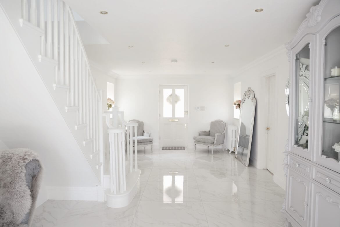 A white room with a white staircase and white furniture
