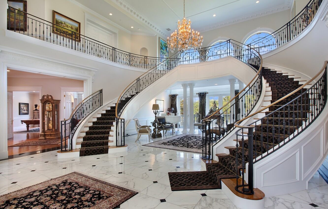 A large foyer with a staircase and chandelier
