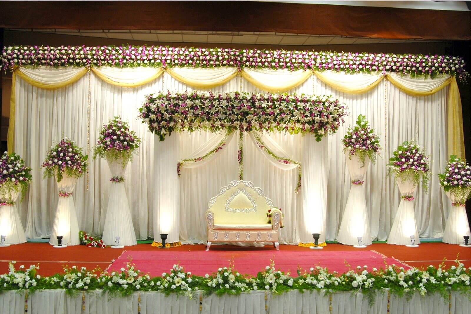 A wedding stage decorated with flowers and greenery
