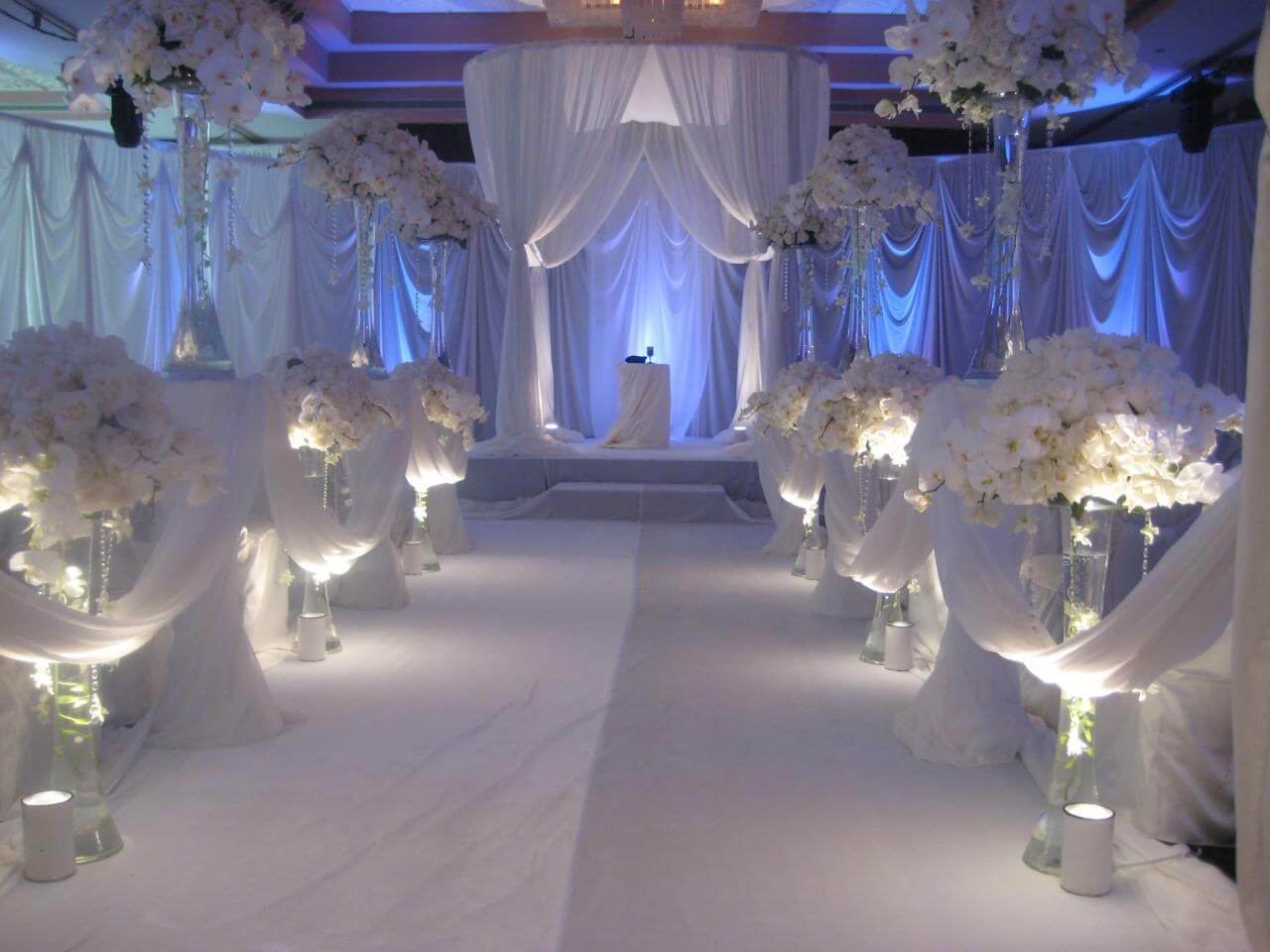 A wedding setup with white flowers and candles

