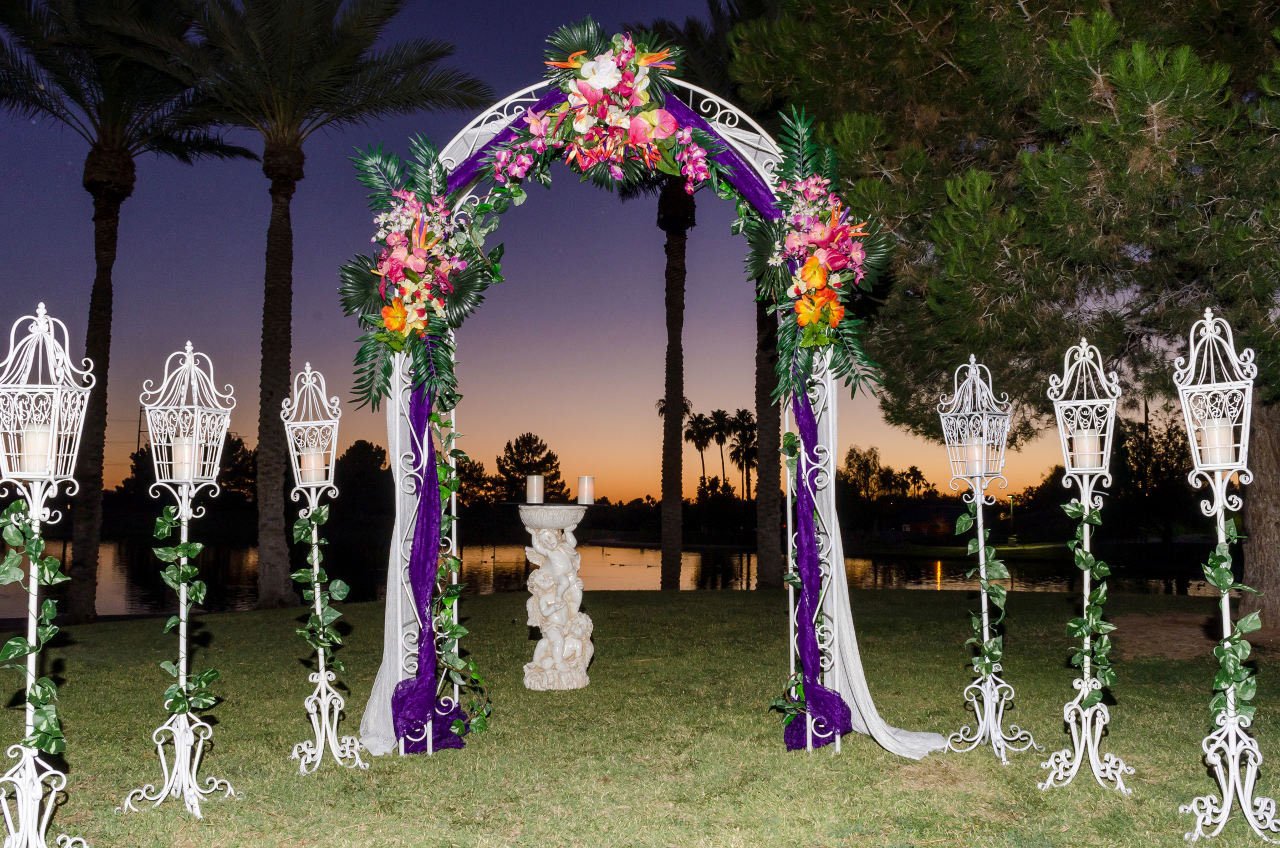 A wedding arch decorated with flowers and lanterns
