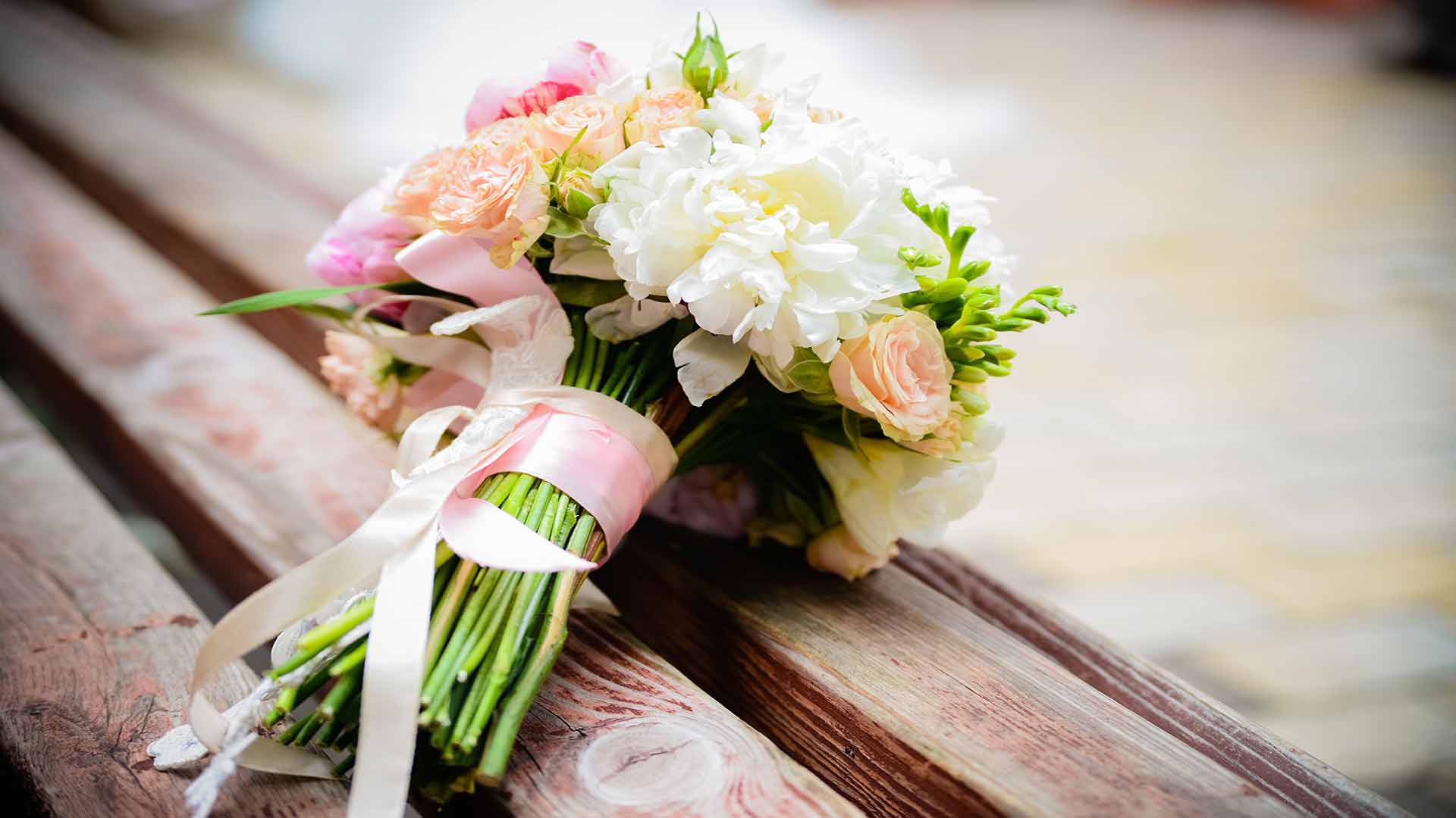 A bouquet of flowers sitting on top of a wooden bench
