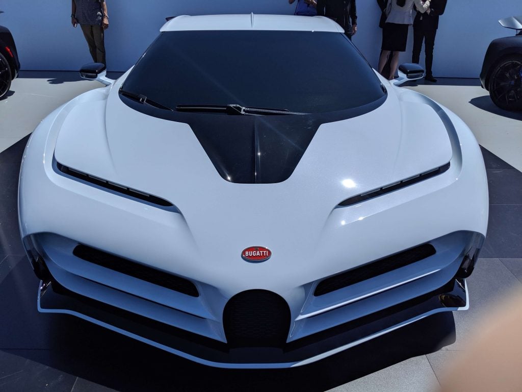 A white  Bugatti Centodieci car is on display at a car show
