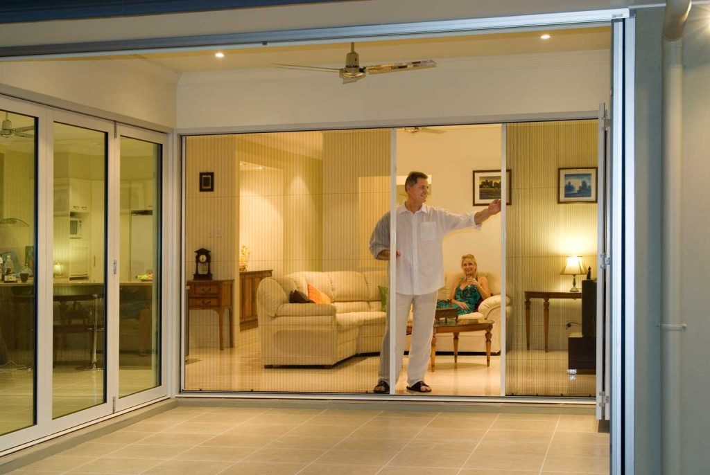 A man standing in front of a sliding glass door
