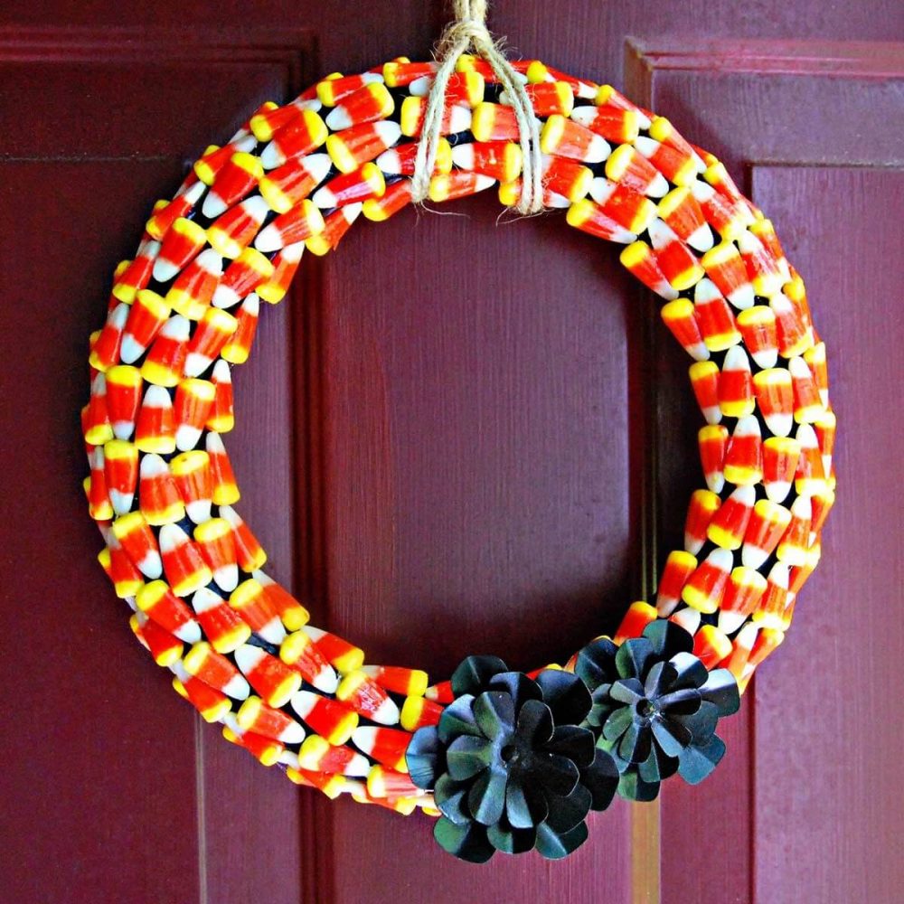 A colorful wreath hanging on a red door

