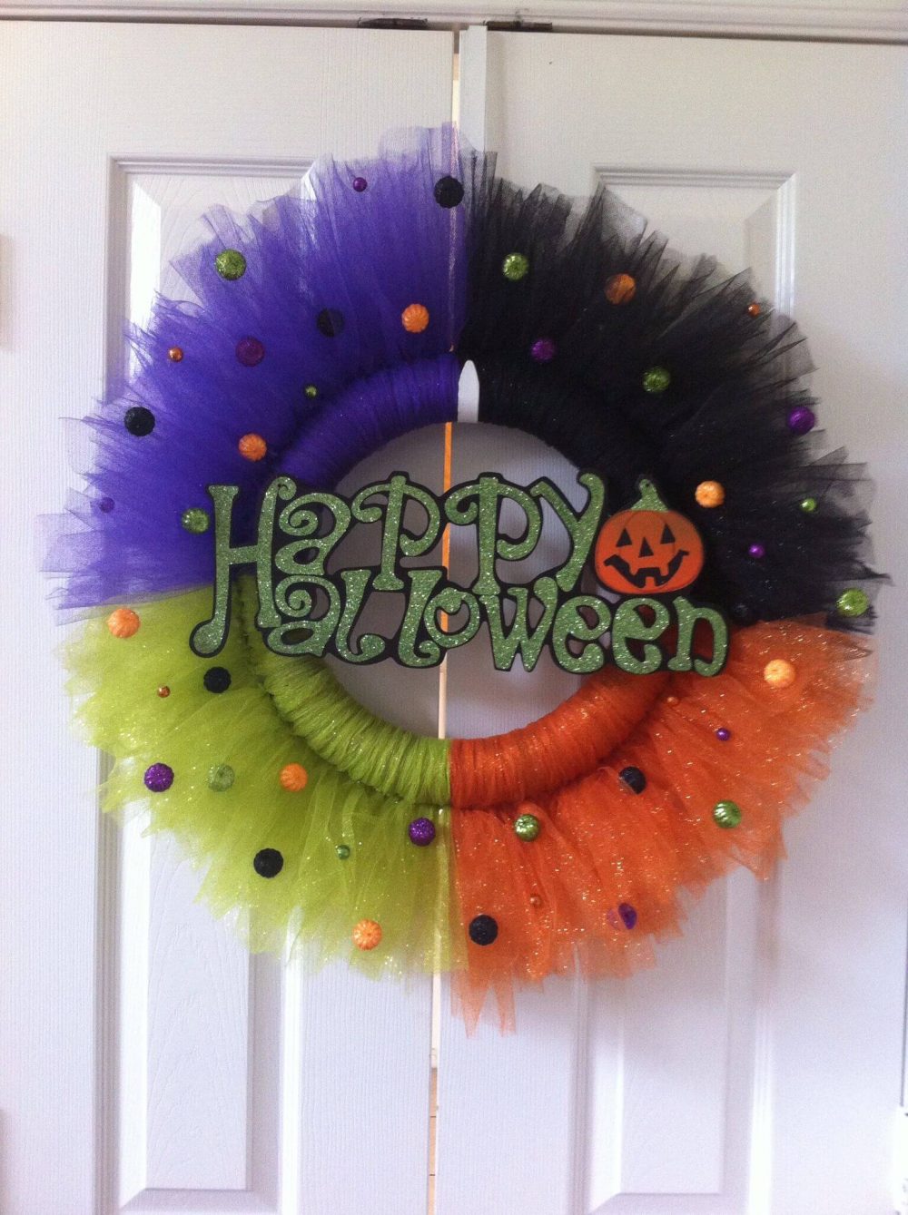 A wreath with a happy halloween sign on it
