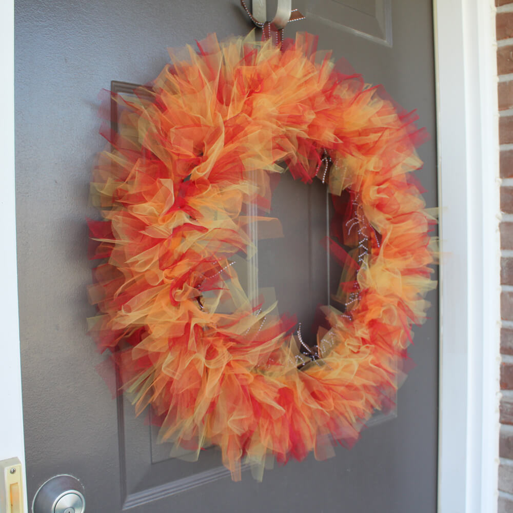 A wreath is hanging on the front door of a house
