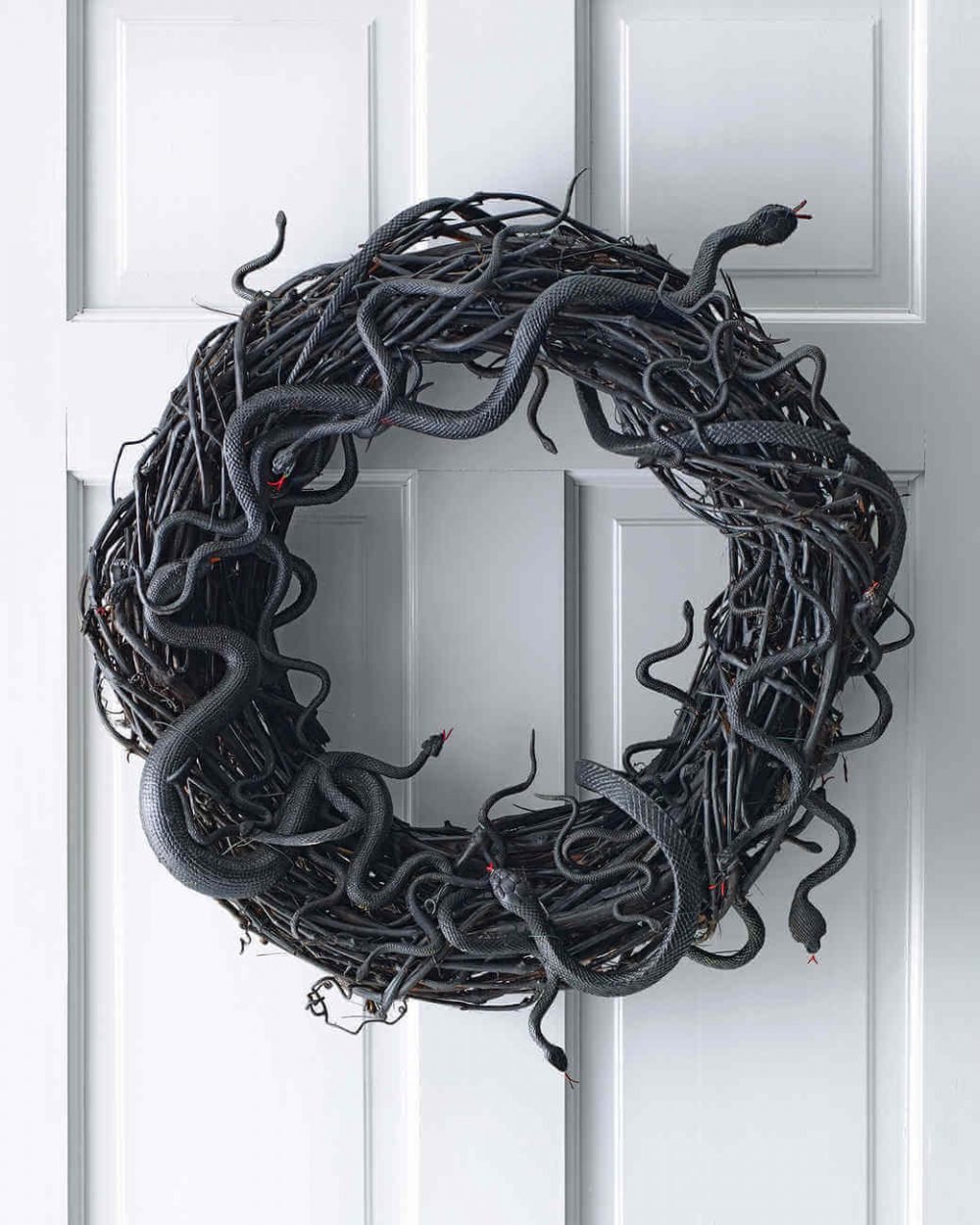 A wreath with a snake on it hanging on a door
