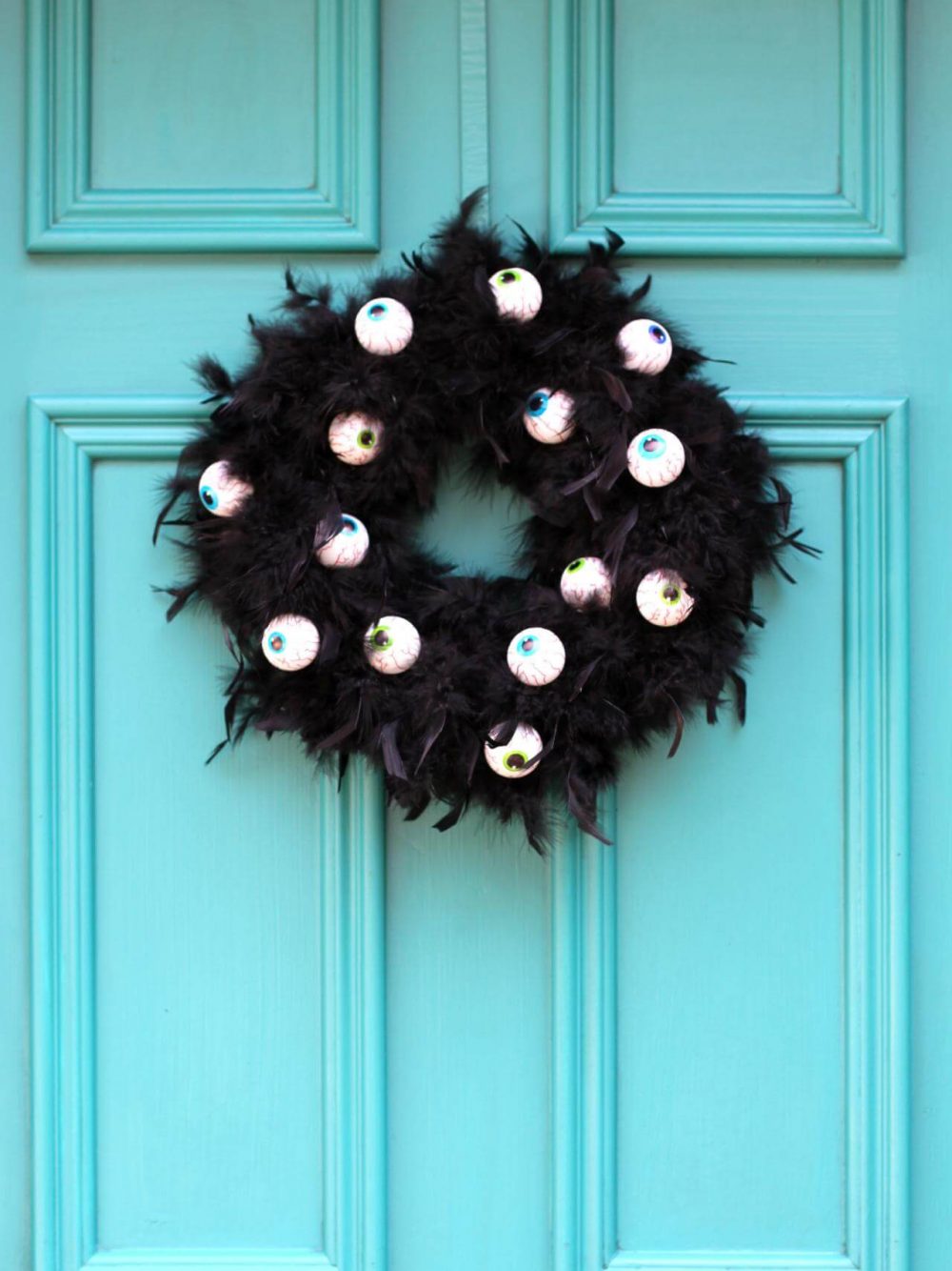 A blue door with a black wreath on it
