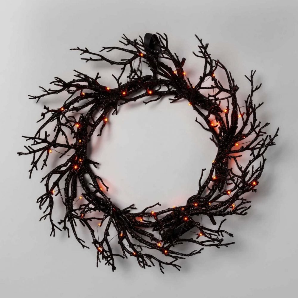 A wreath made out of branches with lights
