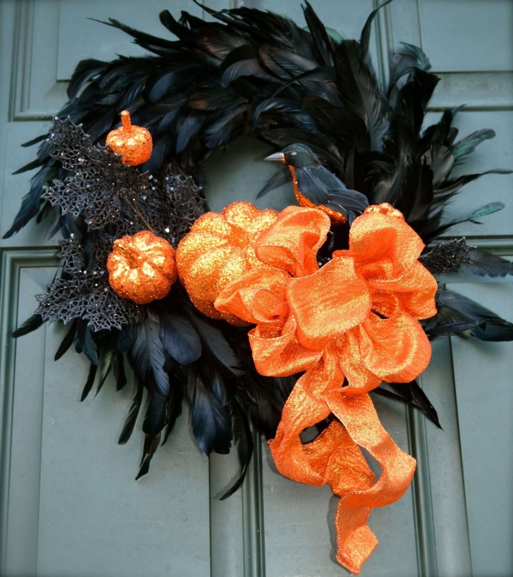 A wreath with orange and black decorations on a door
