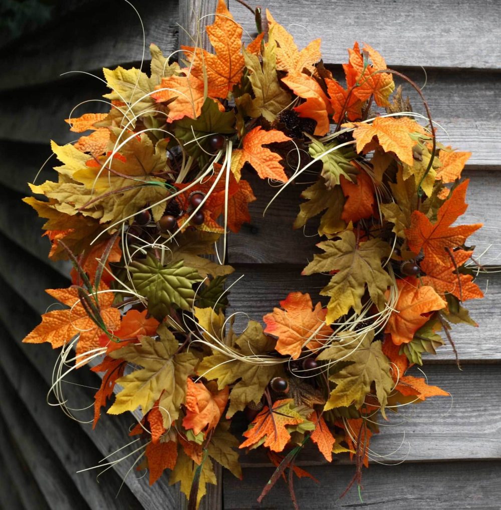A wreath with orange and yellow leaves on it
