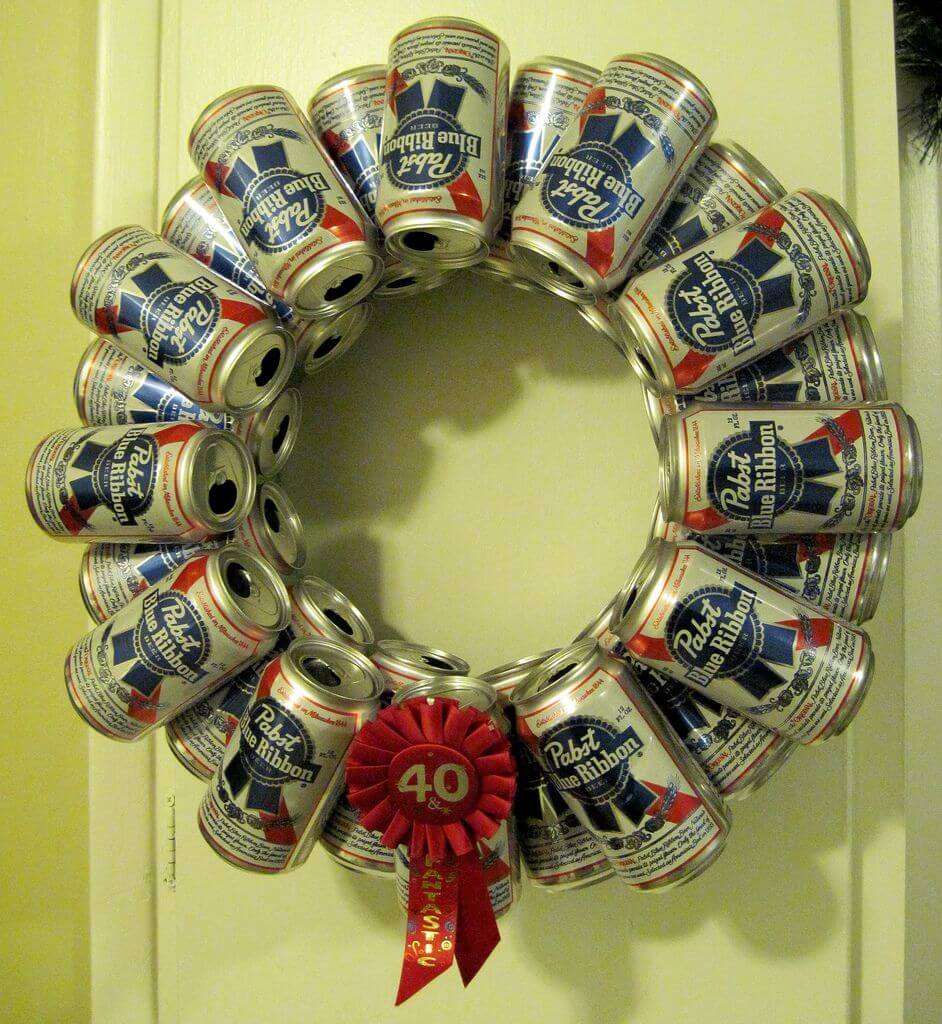 A wreath made out of cans with a red bow
