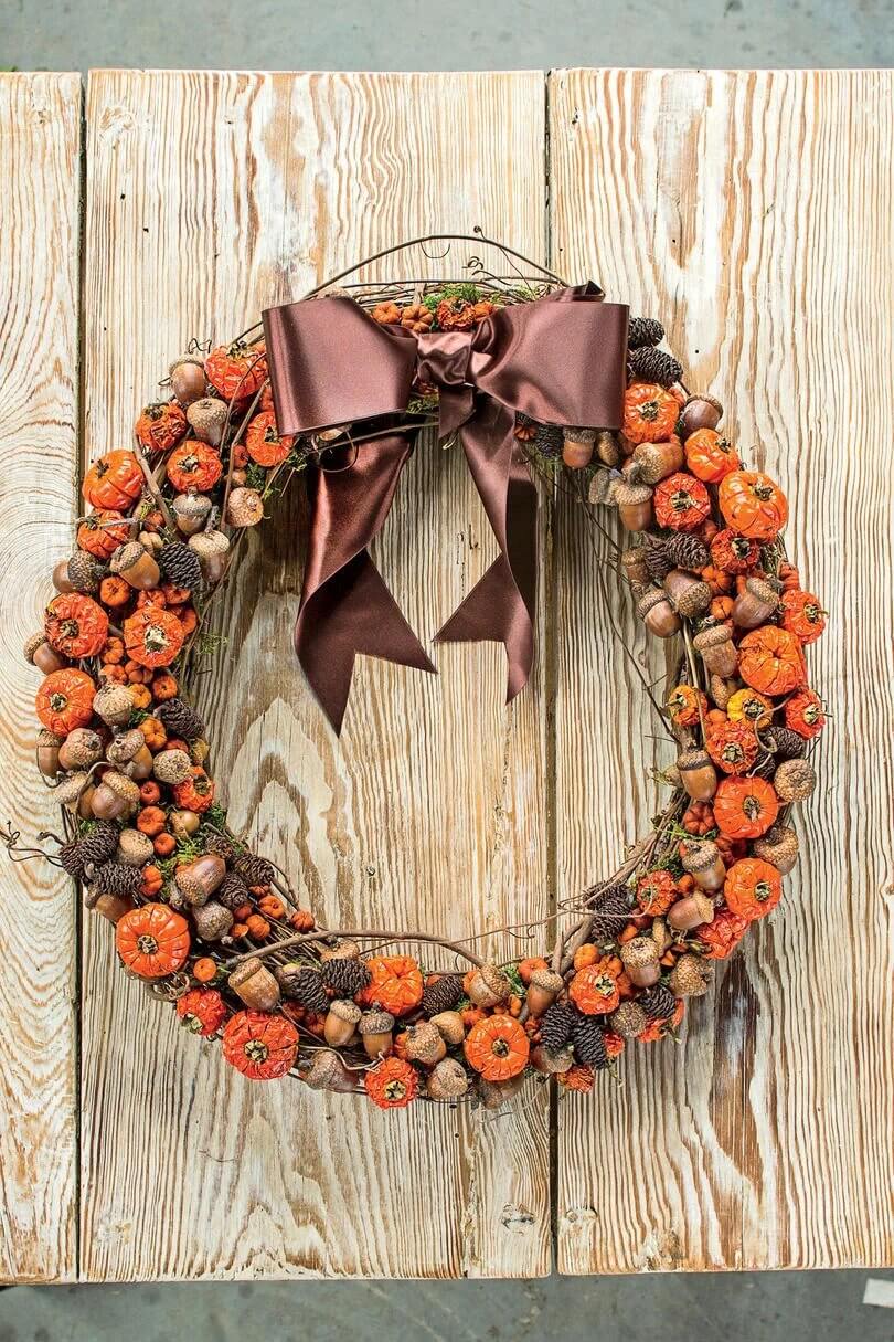 A wreath with a bow hanging on a wooden wall
