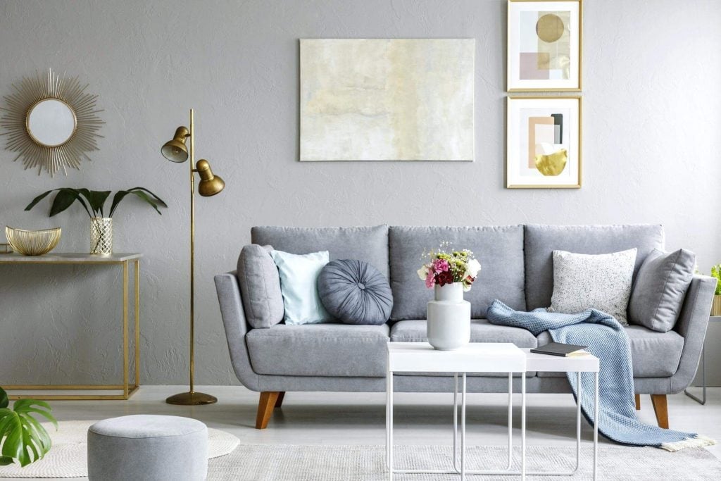 A living room with a gray couch and a white coffee table
