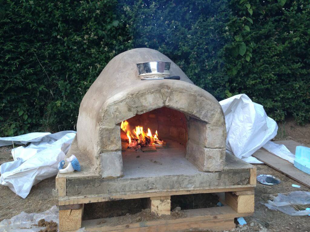 A stone oven with flames burning inside of it
