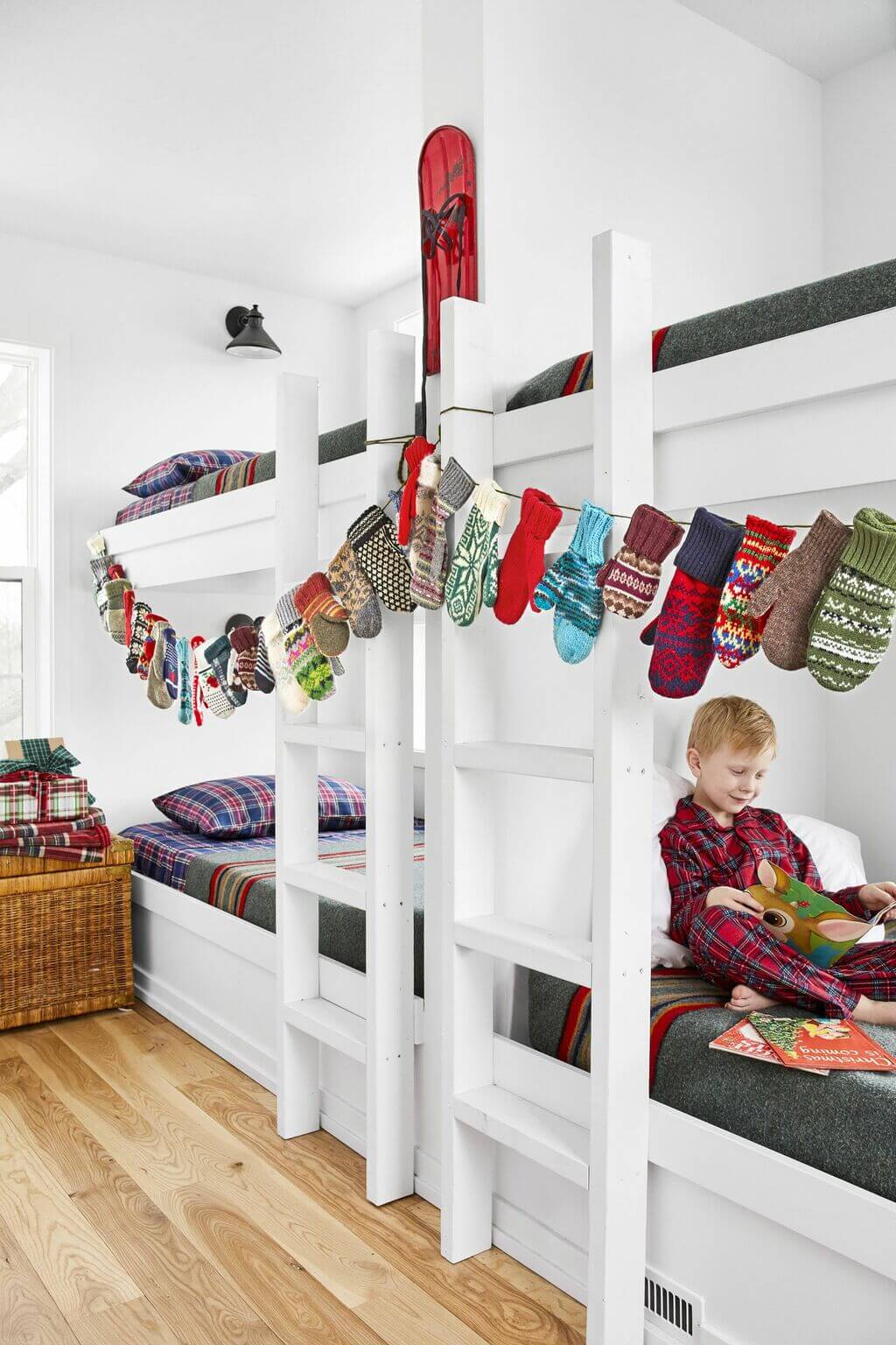 A young boy sitting on a bunk bed reading a book
