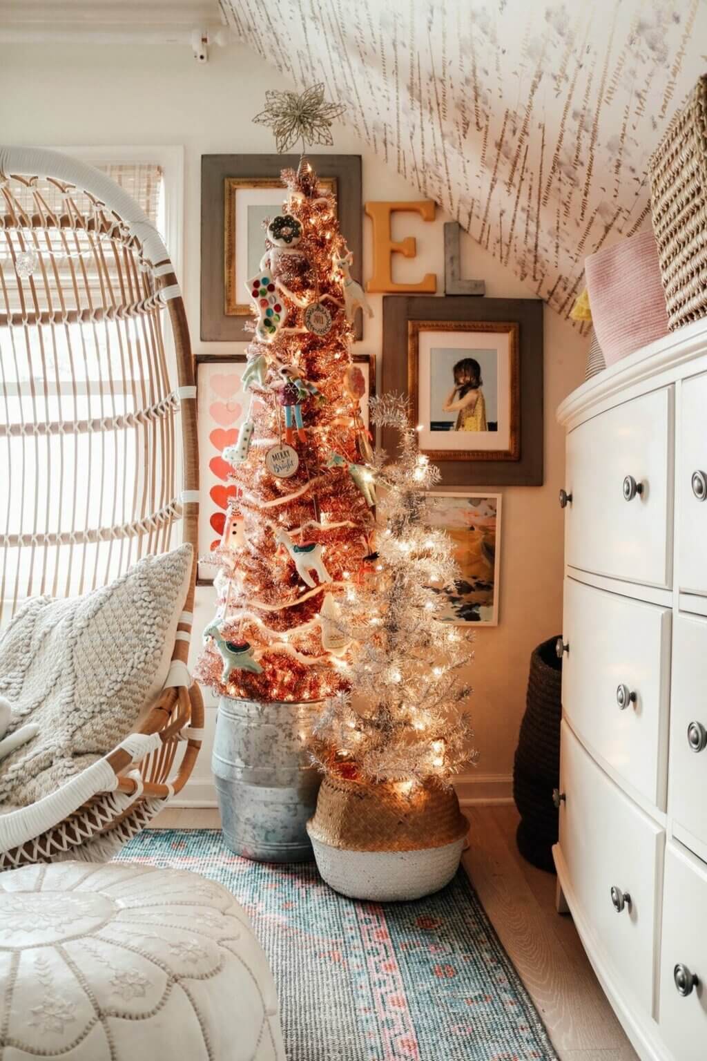 A white christmas tree in a room with pictures on the wall
