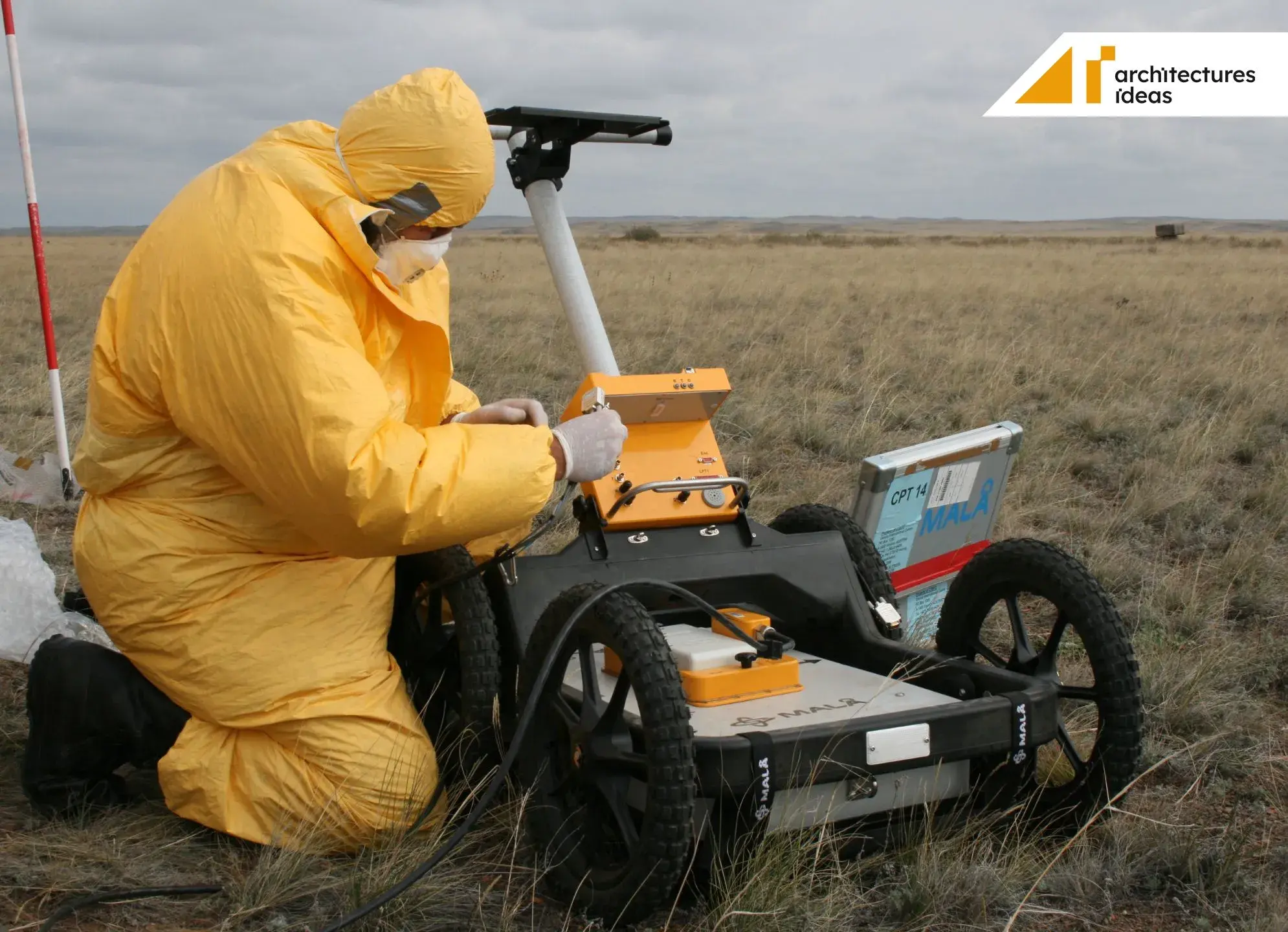 A man standing next to a small orange and black Ground Penetrating Radar
