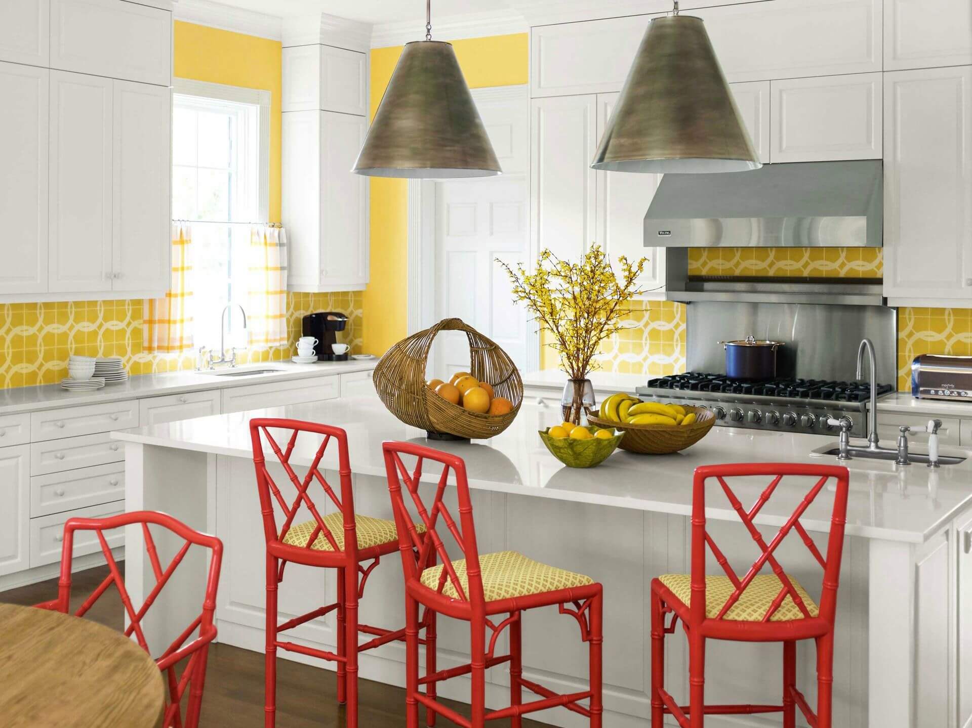 A kitchen with yellow walls and red stools.