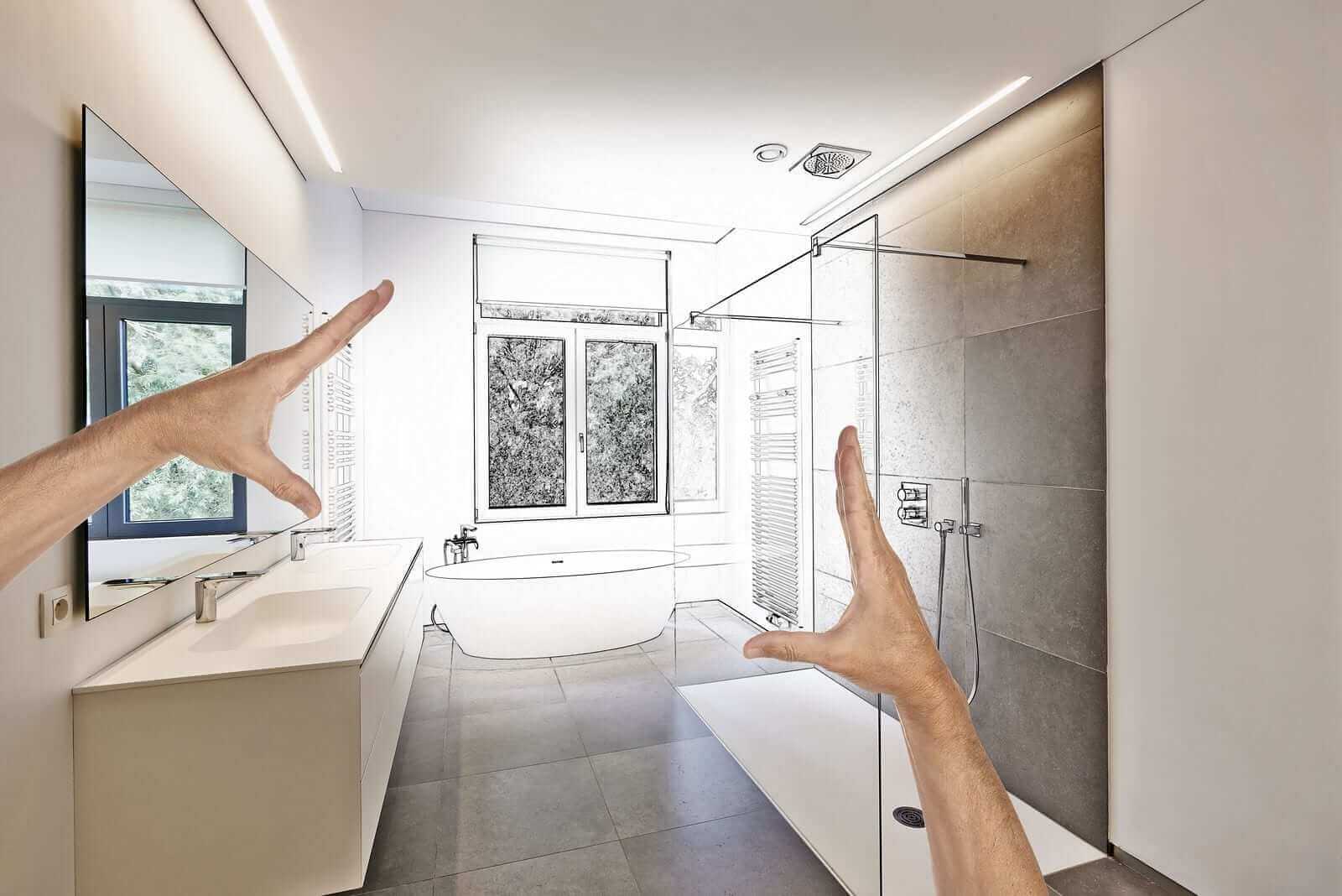 A person's hand pointing at a drawing of a bathroom
