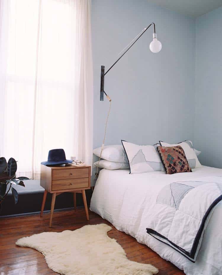 A bedroom with a white bed and a white rug
