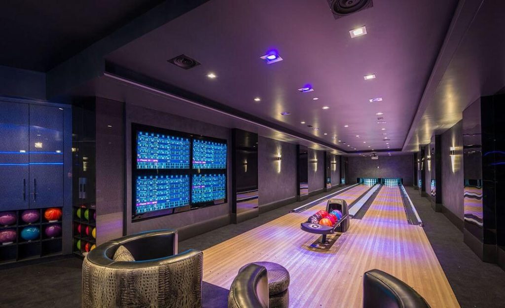 A bowling alley with bowling balls and bowling chairs
