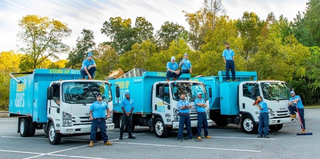 A group of men standing on top of trucks in a parking lot
