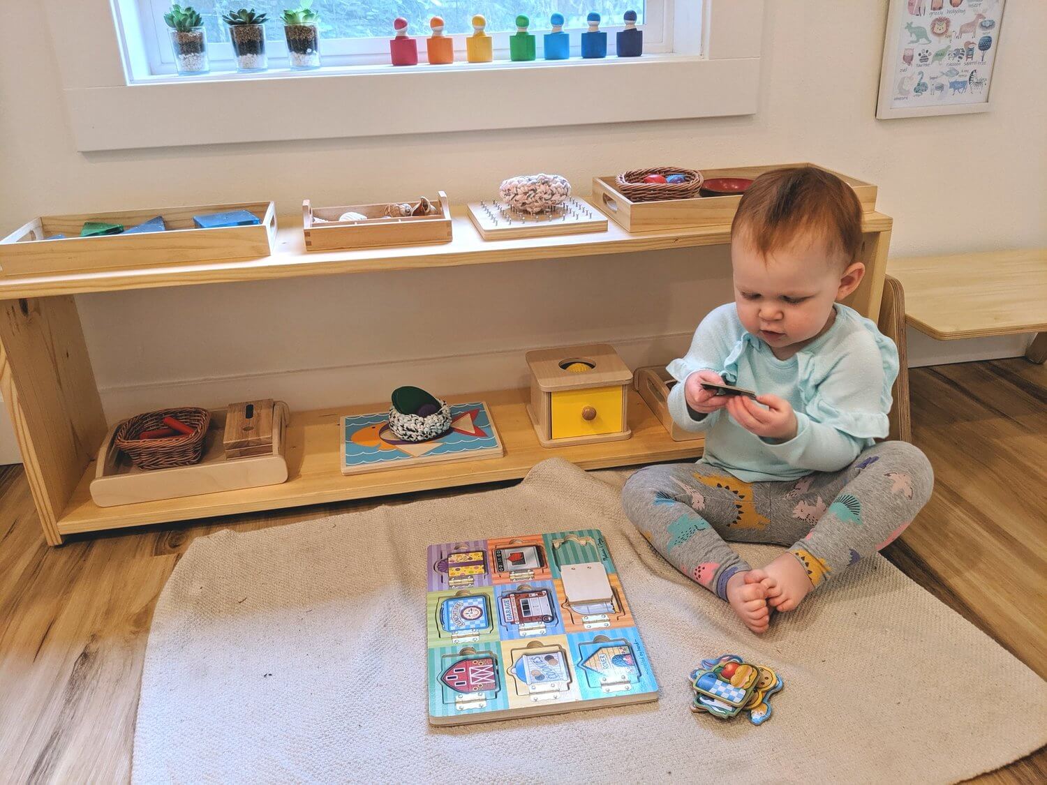 A baby sitting on the floor playing with toys
