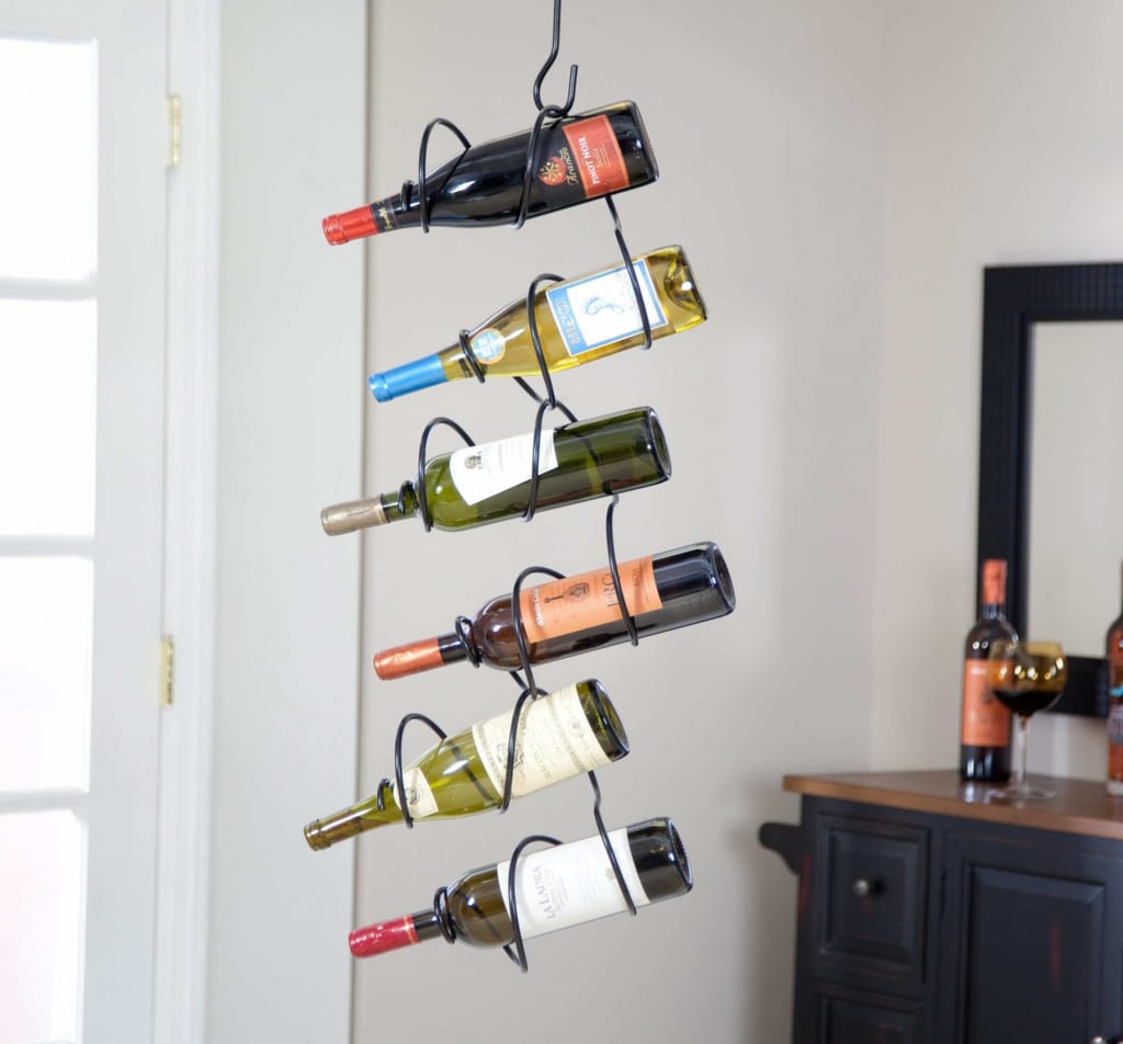 A wall mounted wine rack holding several bottles of wine
