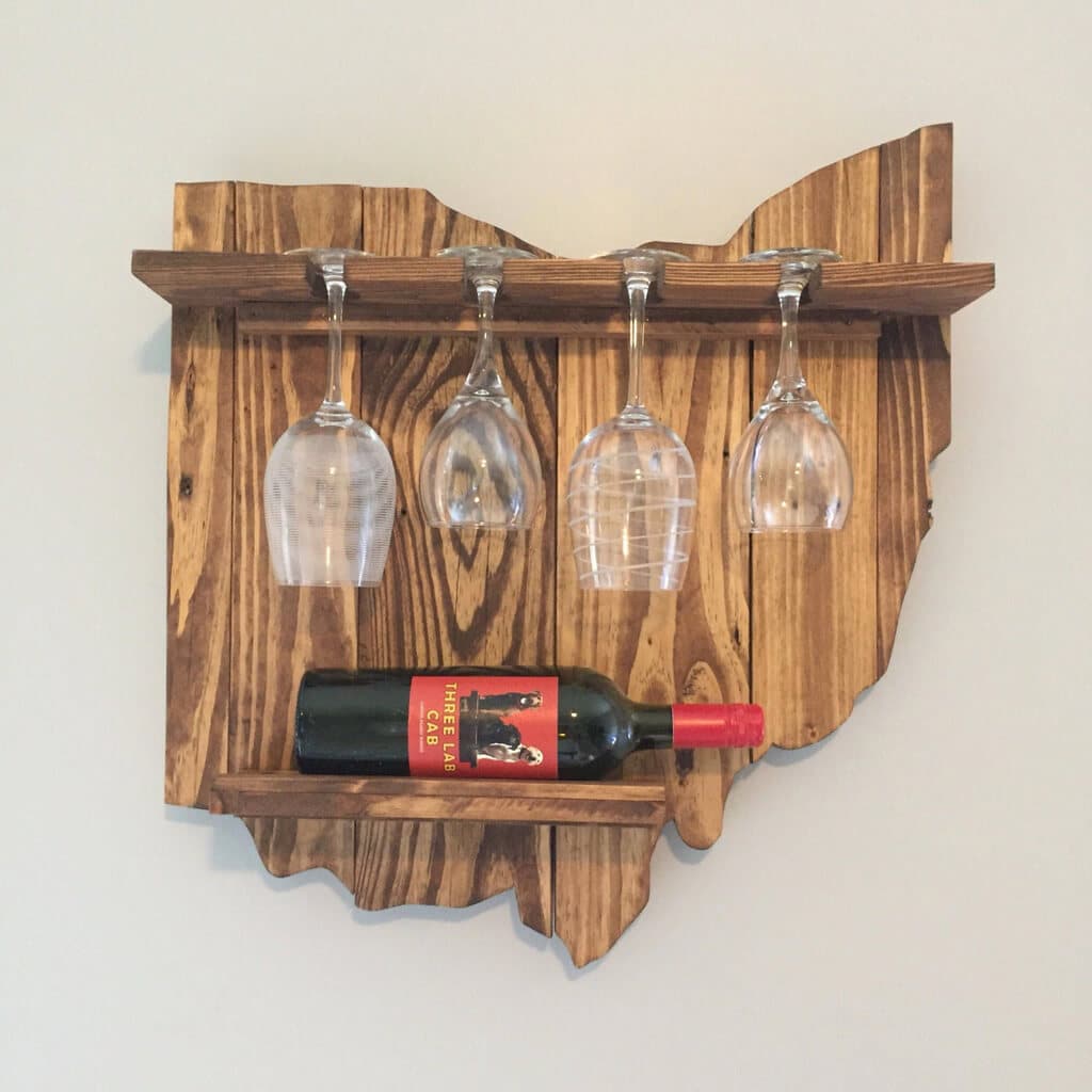 A wooden wine rack with wine glasses on it
